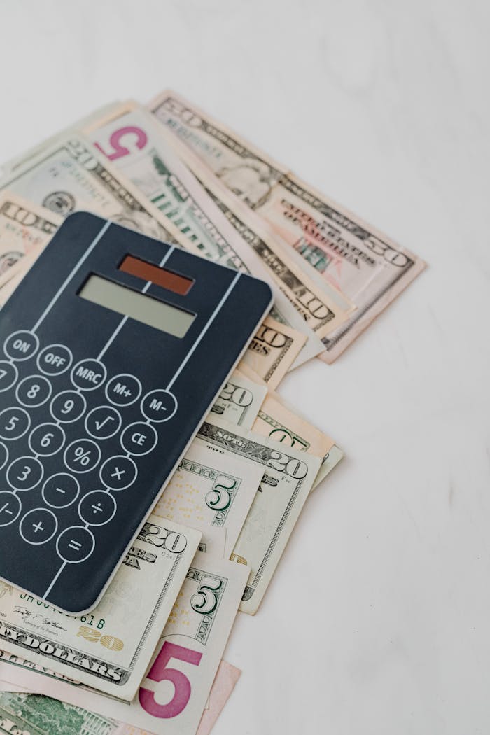 about-us Calculator and US dollar banknotes, symbolizing finance and budgeting.