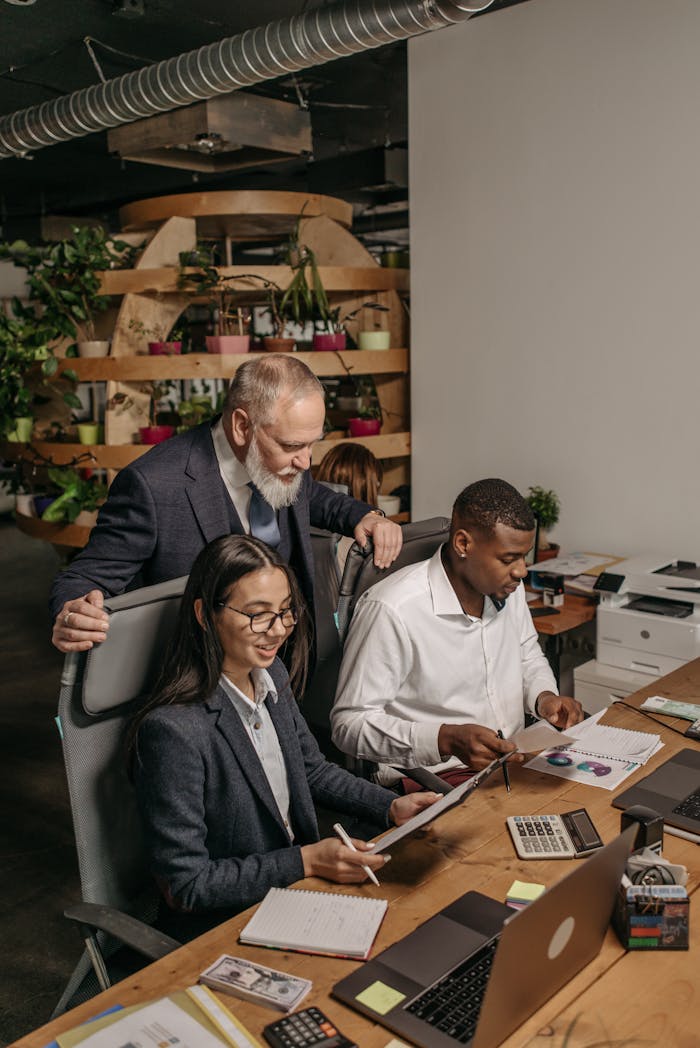 heros-img Professional team collaborating in a modern office environment with documents and technology.